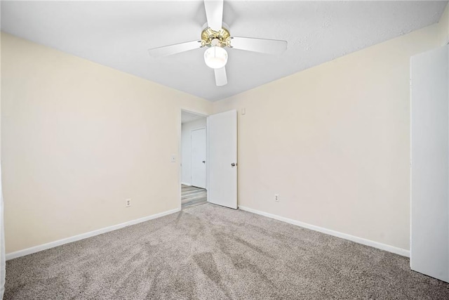 unfurnished room featuring a ceiling fan, baseboards, and carpet flooring