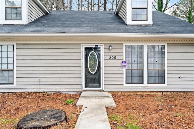 property entrance featuring roof with shingles