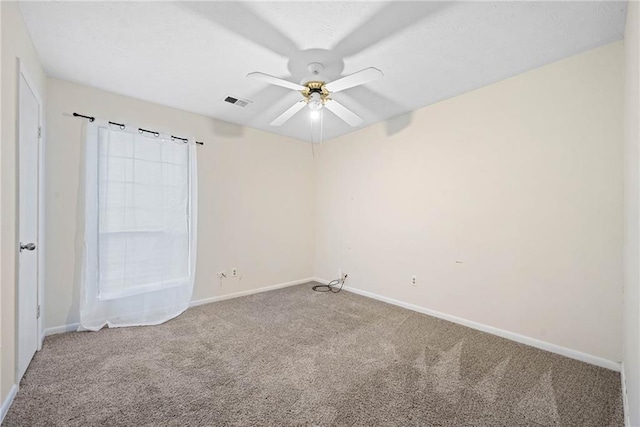 carpeted empty room with visible vents, a textured ceiling, baseboards, and a ceiling fan