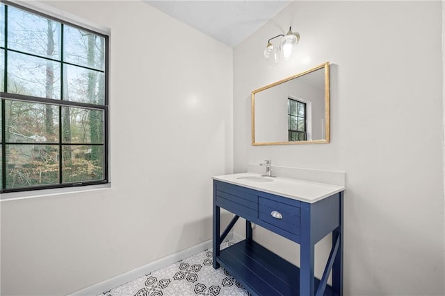 bathroom with vanity, baseboards, a wealth of natural light, and tile patterned floors