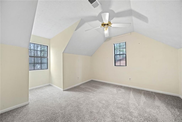 additional living space with lofted ceiling, ceiling fan, carpet floors, visible vents, and baseboards