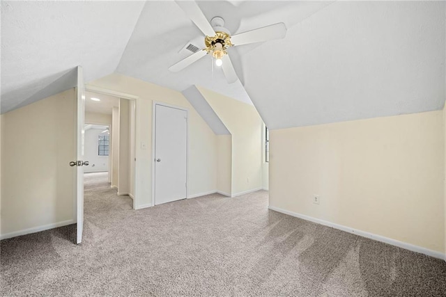 additional living space with visible vents, baseboards, ceiling fan, vaulted ceiling, and carpet floors