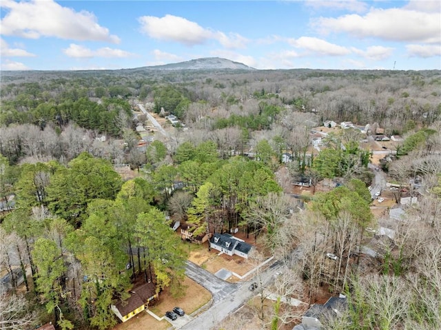 drone / aerial view with a wooded view and a mountain view