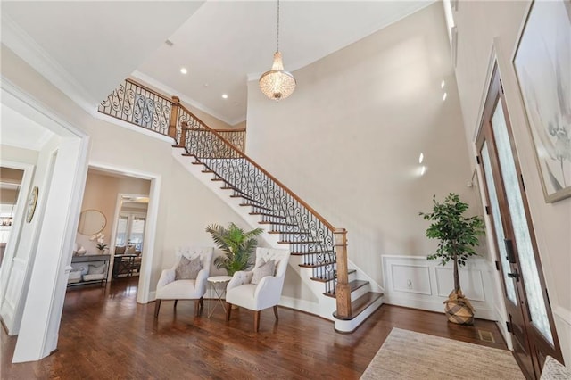 foyer entrance with recessed lighting, a high ceiling, wood finished floors, stairway, and crown molding