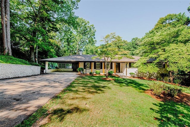 view of front of house featuring a carport, concrete driveway, and a front yard