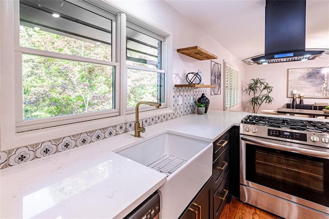 kitchen featuring light countertops, a sink, gas range, and island range hood