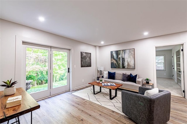 living area with baseboards, light wood-type flooring, and recessed lighting