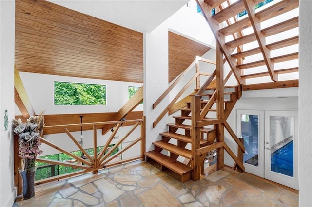 staircase featuring wood ceiling, a high ceiling, and french doors