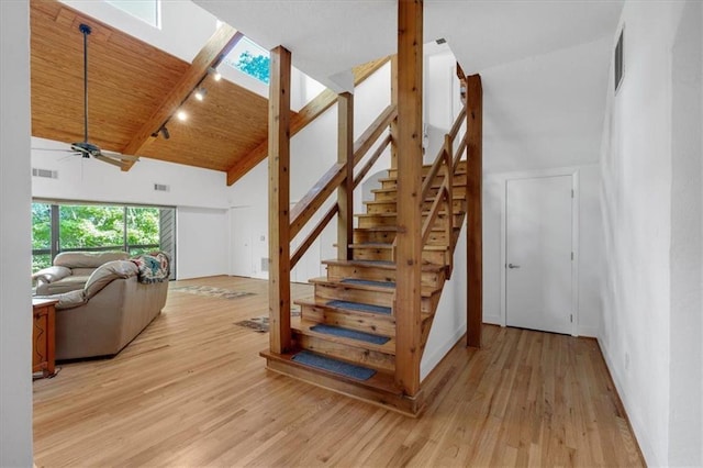 staircase with wood ceiling, a skylight, wood-type flooring, and ceiling fan