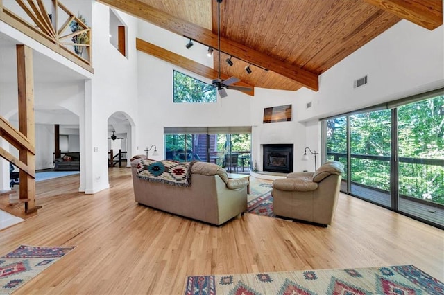 living room featuring high vaulted ceiling, hardwood / wood-style flooring, beam ceiling, and ceiling fan