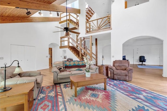 living room featuring beamed ceiling, high vaulted ceiling, ceiling fan, wood ceiling, and hardwood / wood-style flooring