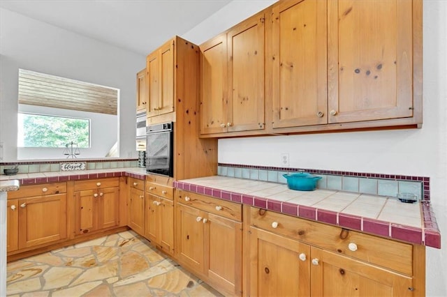 kitchen with tile counters and black oven