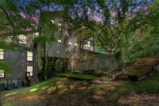 property exterior at dusk featuring central air condition unit