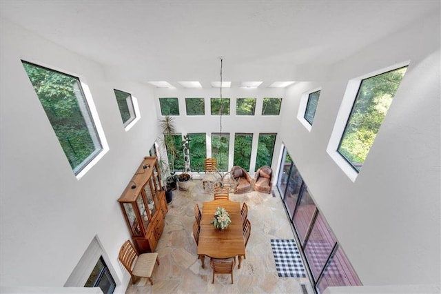 living room featuring a wealth of natural light, a high ceiling, and a fireplace