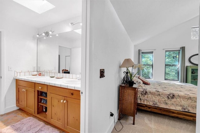 bathroom featuring vanity and vaulted ceiling with skylight