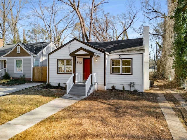 view of front of property with central AC and a front yard