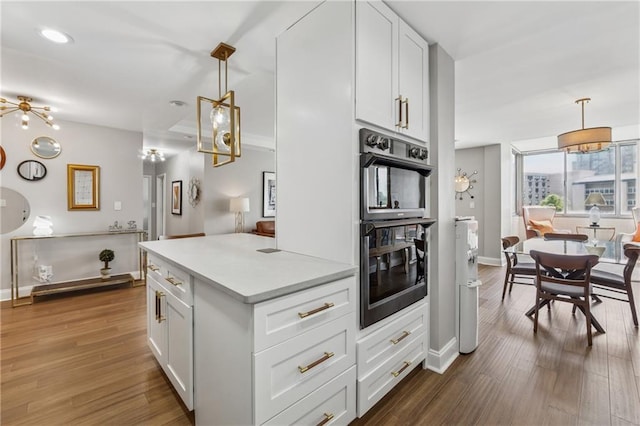 215 Piedmont Ave NE Unit 506, Atlanta, GA 30308 - kitchen featuring baseboards, light countertops, white cabinets, dark wood-type flooring, and dobule oven black
