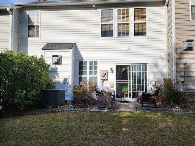 back of house featuring central AC unit, a patio area, and a lawn