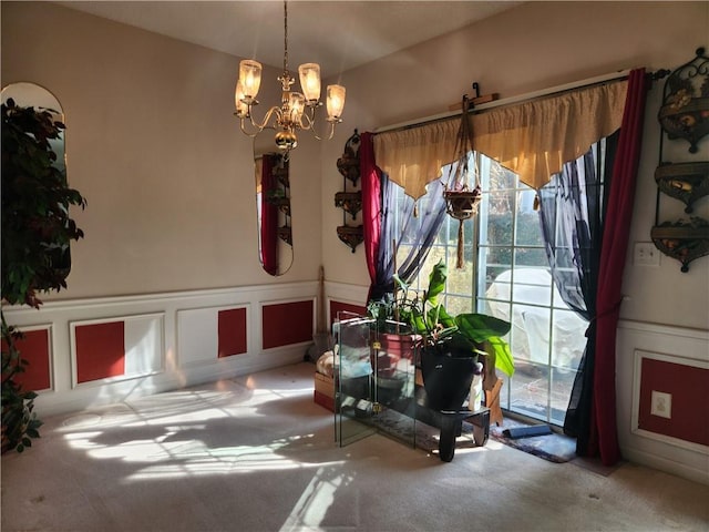 dining area featuring carpet and an inviting chandelier