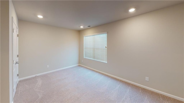 carpeted spare room with visible vents, recessed lighting, and baseboards