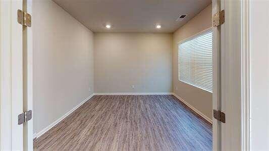 unfurnished room featuring recessed lighting, visible vents, baseboards, and wood finished floors