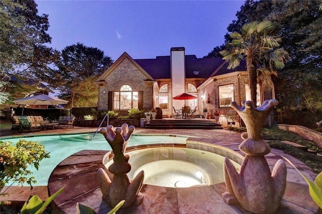 4478 Longmead Rd, Flowery Branch, GA 30542 - back of house with an in-ground hot tub, a patio area, a chimney, and brick siding