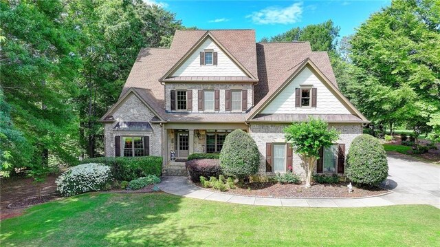 4478 Longmead Rd, Flowery Branch, GA 30542 - view of front of property featuring a front yard, a standing seam roof, a porch, and brick siding