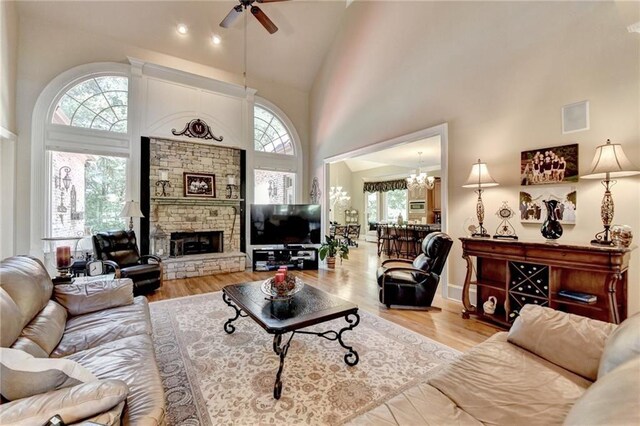 4478 Longmead Rd, Flowery Branch, GA 30542 - living area featuring high vaulted ceiling, ceiling fan, a chandelier, a fireplace, and wood finished floors