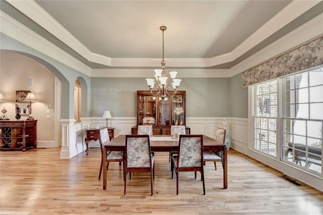 4478 Longmead Rd, Flowery Branch, GA 30542 - dining space featuring arched walkways, a raised ceiling, a chandelier, light wood-style floors, and ornamental molding