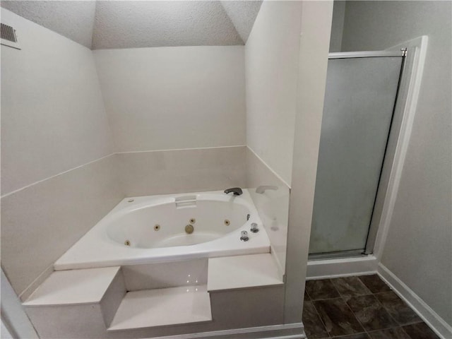 bathroom featuring vaulted ceiling, a textured ceiling, and shower with separate bathtub