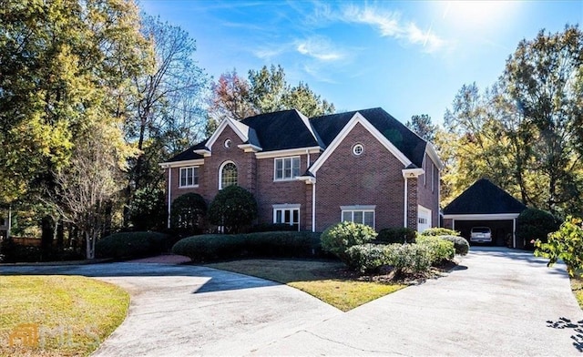 view of front of home with a detached carport, concrete driveway, brick siding, and a front yard