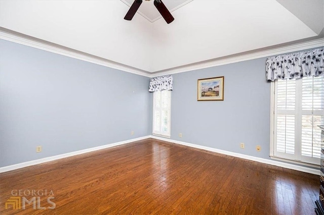 spare room featuring dark wood finished floors, a ceiling fan, baseboards, and ornamental molding