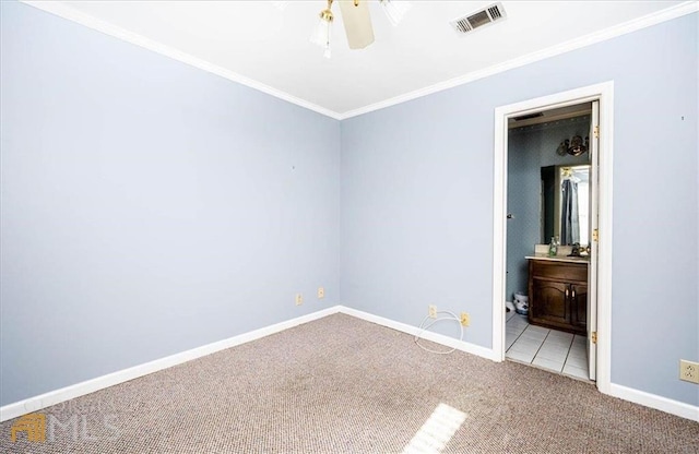 unfurnished bedroom featuring visible vents, ensuite bathroom, carpet floors, crown molding, and baseboards