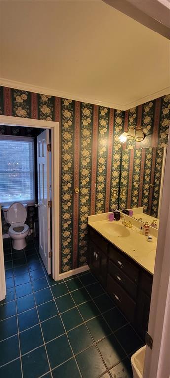 bathroom featuring tile patterned floors, vanity, and wallpapered walls