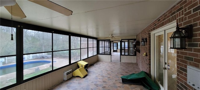 unfurnished sunroom featuring a ceiling fan