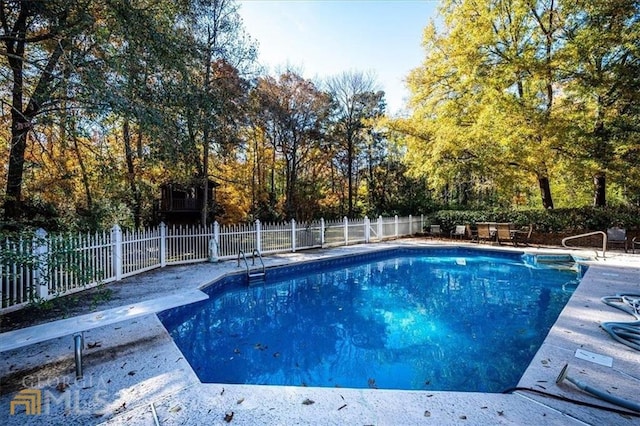 view of swimming pool featuring a diving board, a fenced in pool, a patio area, and fence