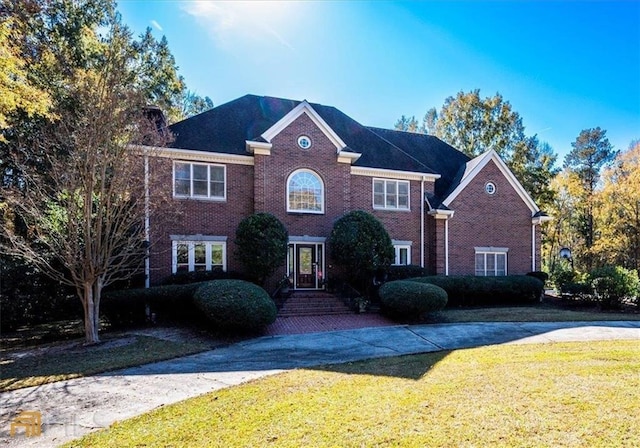 view of front of house with a front lawn and brick siding