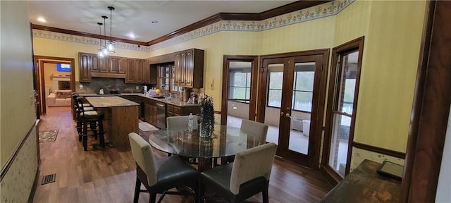 dining area featuring french doors, visible vents, dark wood-style flooring, and crown molding