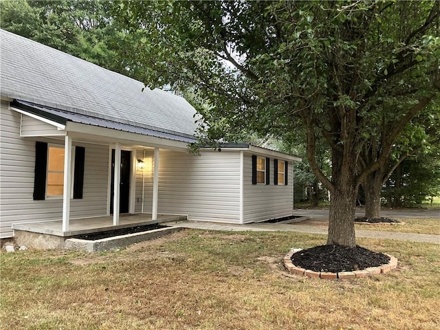 view of property exterior featuring a lawn and a porch