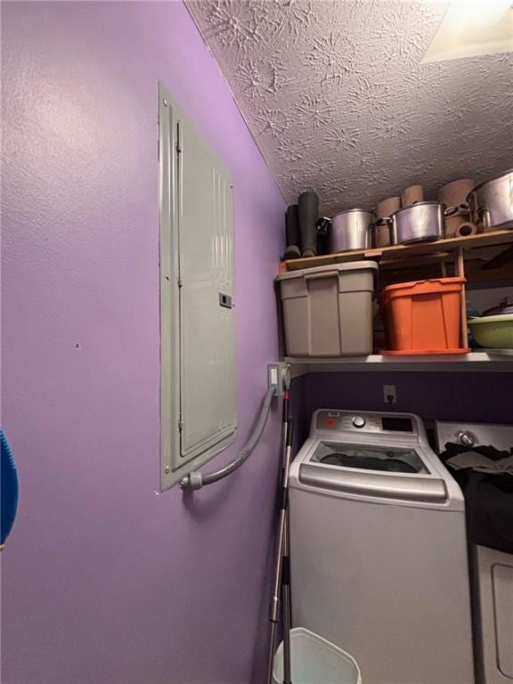 laundry room with laundry area, electric panel, washer / clothes dryer, and a textured ceiling