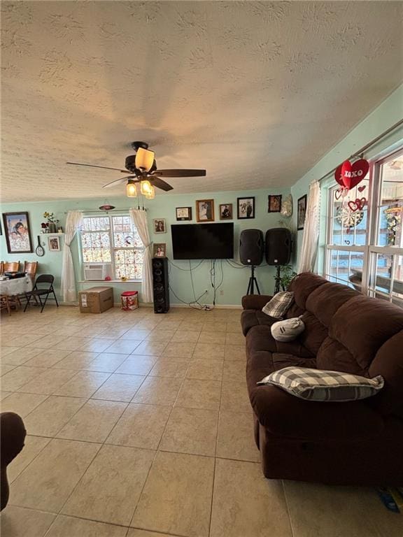 living room featuring light tile patterned flooring, ceiling fan, and a textured ceiling