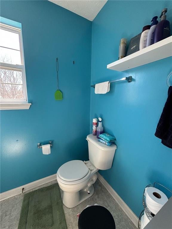 bathroom with wood finished floors, toilet, and baseboards