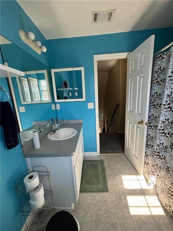 bathroom with baseboards, visible vents, and vanity