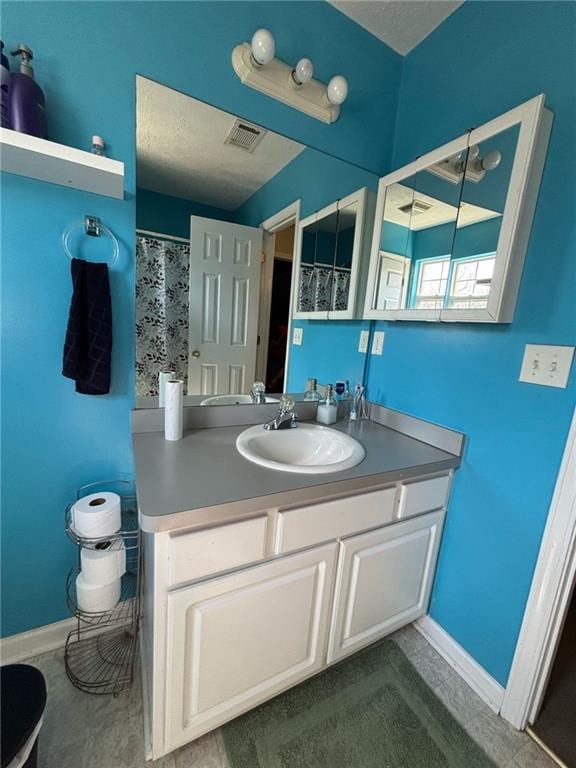 bathroom featuring visible vents, vanity, and baseboards