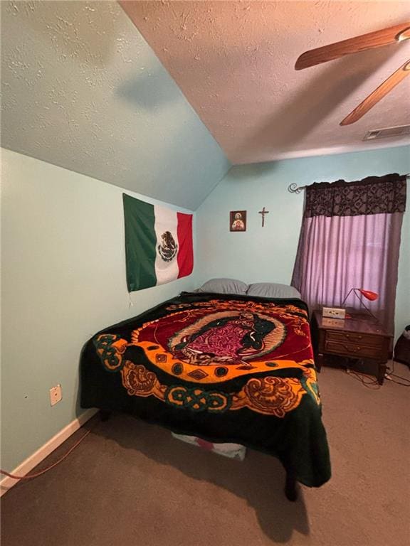 carpeted bedroom featuring visible vents, a ceiling fan, vaulted ceiling, a textured ceiling, and baseboards