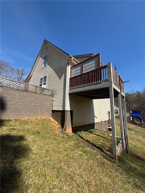 back of house featuring crawl space, a deck, and a yard