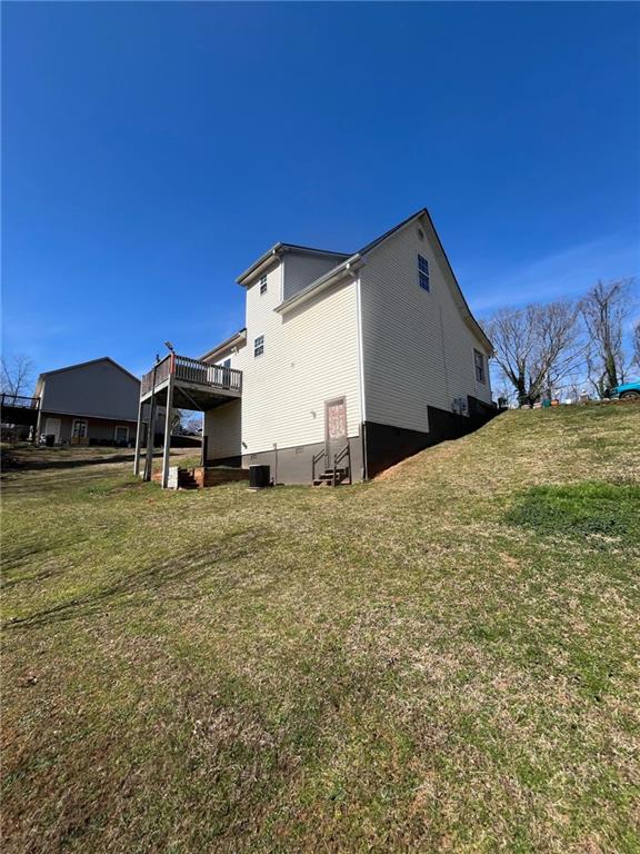 view of home's exterior featuring a deck and a lawn