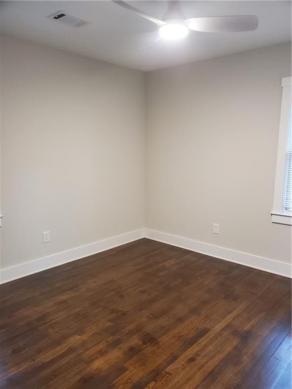 spare room with dark wood-type flooring and ceiling fan