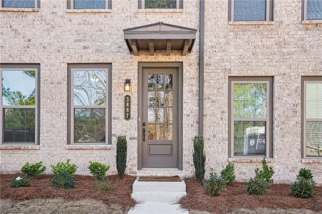 entrance to property featuring brick siding