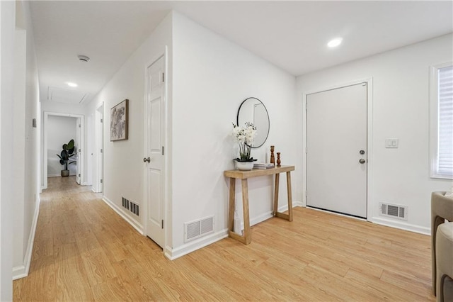 foyer with light wood finished floors, baseboards, visible vents, and recessed lighting